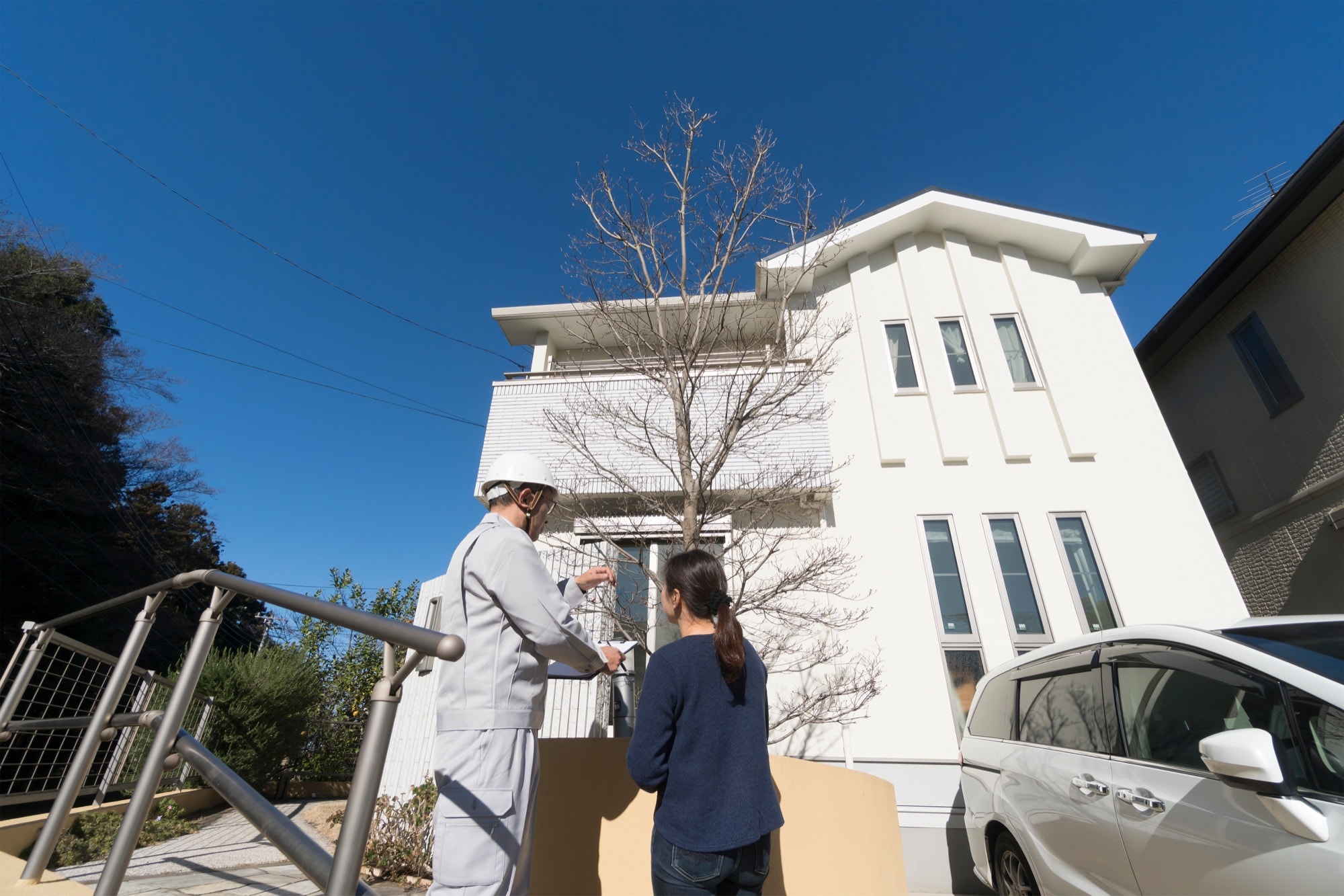外壁リフォーム後の説明をする作業員