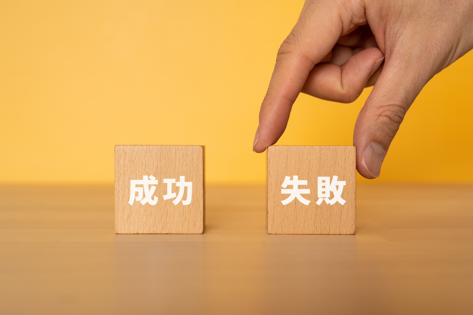失敗と書かれたブロックを選ぶ手