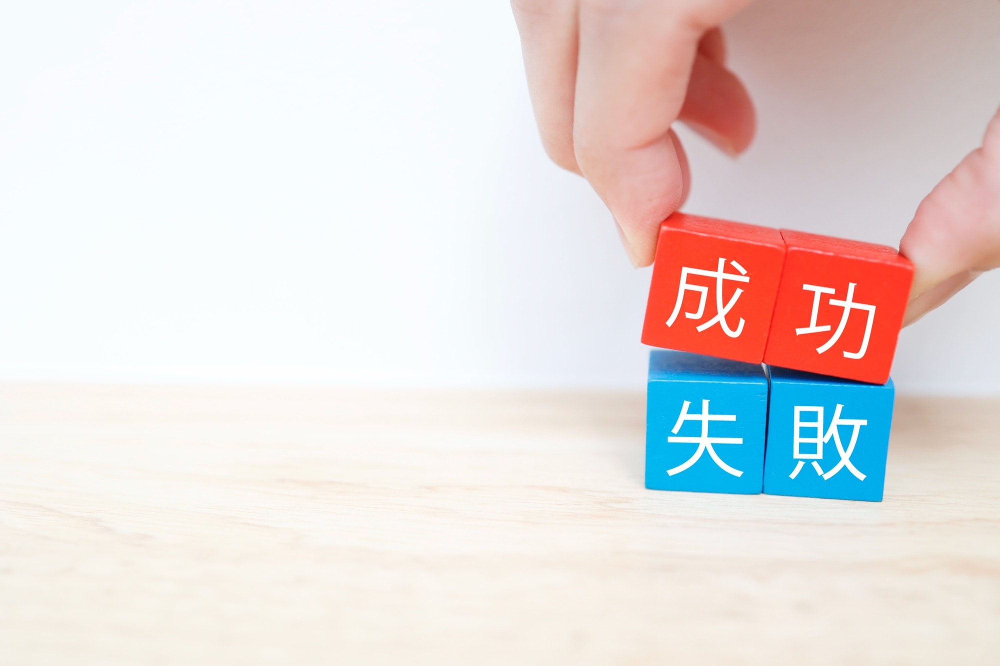 成功と書かれたブロックを選ぶ手